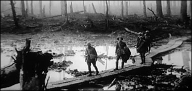 British troops on a walkway over a waterlogged, shelled, battlefield