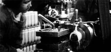 A woman working at a lathe in a factory