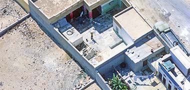 An aerial view of courtyards with a water tanker filling a domestic roof tank