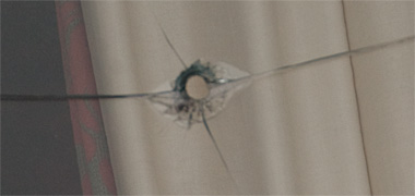 The evidence of a bullet passing from inside to outside a window
