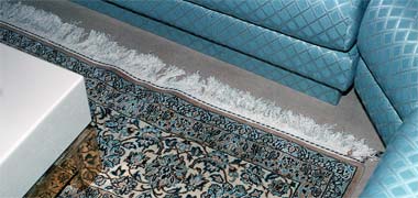 The corner of a room showing the meeting of carpet with chairs