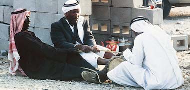 Three musicians tuning a drum