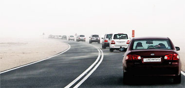 A line of traffic in a light dust storm