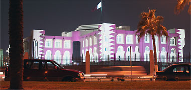The Diwan al Amiri lit with the Qatari flag
