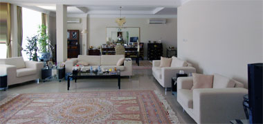 A modern sitting room with adjacent dining room