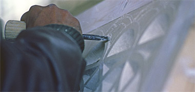 A plasterwork panel being carved at an angle