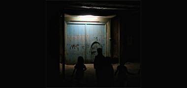 A door, seen by night, in an area of Doha about to be demolished