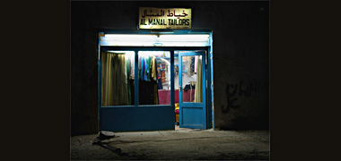 A shop, seen by night, in an area of Doha about to be demolished