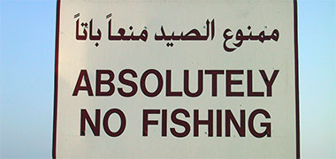A ‘no fishing’ sign illustrating the difference between Roman upper case and Arabic lettering