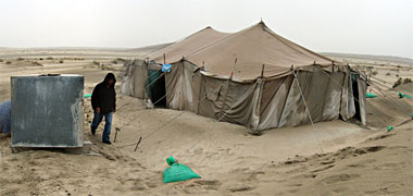 Pegging a modern tent with sandbags