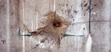 The results of shrapnel on a wall