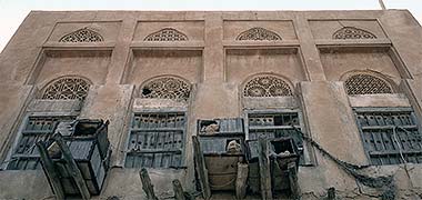 An external view of carved naqsh ventilation panels in an old Wakra building