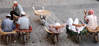 Porters resting on their wheelbarrows in the suq