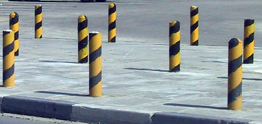 Security posts located to prevent parking on or access over a pedestrian paving