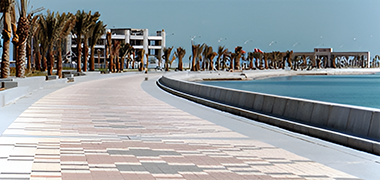 A view along the Corniche with the Gulf Organisation for Industrial Consultancy and a celebratory arch over the road on the right