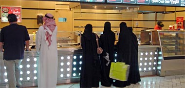Male and female Qataris waiting to be served at a fast food outlet