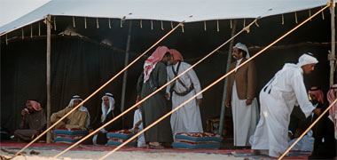 A guest being greeted at the entrance to a tent