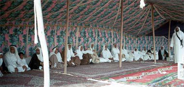 Qatari guests in a tent, with bodyguard