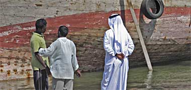 Owner and workers inspect a dhow