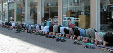 Men praying outside a showroom