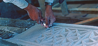 Naqsh plasterwork being carved in a simple frame