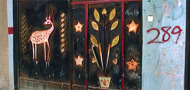 Detail of steel entrance gates with gazelle, plant and stars
