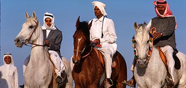 Mounted Qataris riding in the desert