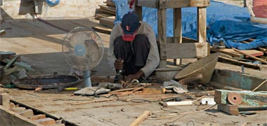 A crew man carrying out repairs on deck