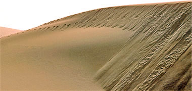 Sand slipping down the face of a dune
