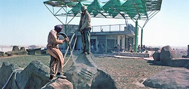 Two workers spraying concrete onto formwork to create artificial rocks