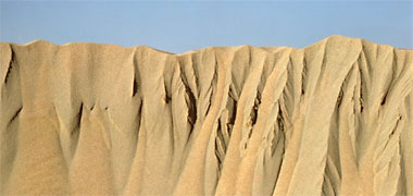 The top twenty centimetres of a sand dune from its leeward side and with no wind blowing